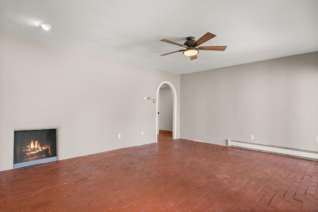 384 Chaparral Ln, Corrales, NM 87048 - unfurnished living room with ceiling fan, baseboard heating, arched walkways, and a warm lit fireplace