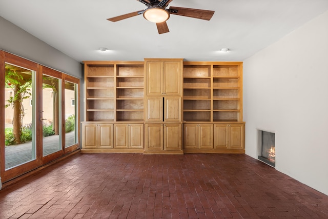 384 Chaparral Ln, Corrales, NM 87048 - unfurnished living room featuring brick flooring, ceiling fan, and a lit fireplace
