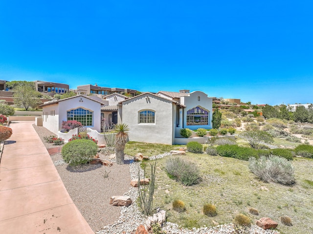 mediterranean / spanish-style house with stucco siding and a tile roof