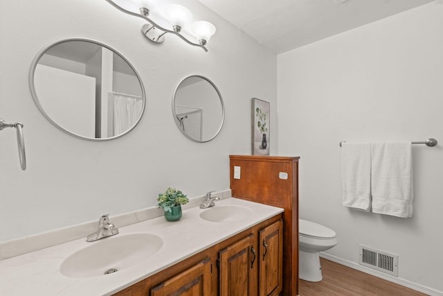 11 Riverside Rd, Peralta, NM 87042 - bathroom featuring toilet, double vanity, wood finished floors, and baseboards