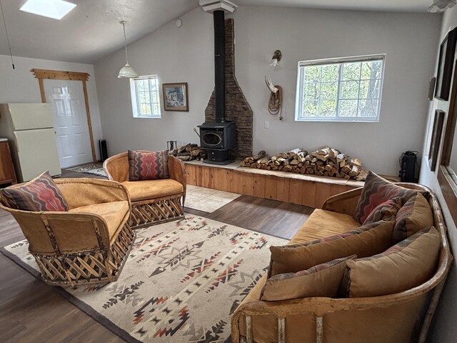 37 Lasso Ln, Pie Town, NM 87827 - living room with a wood stove, wood finished floors, vaulted ceiling, and a skylight