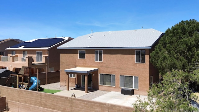 1181 Colibri Ave NW, Los Lunas, NM 87031 - rear view of house with a patio, stucco siding, a playground, and fence