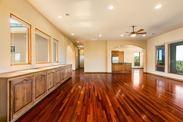 9 Canon Escondido, Sandia Park, NM 87047 - unfurnished living room with arched walkways, dark wood-type flooring, recessed lighting, ceiling fan, and baseboards