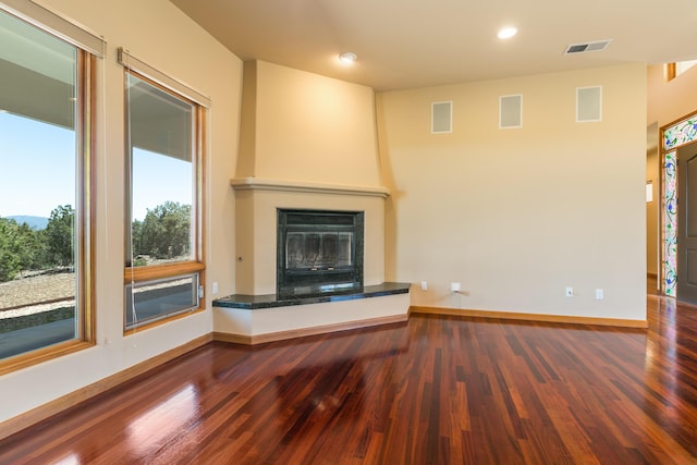 9 Canon Escondido, Sandia Park, NM 87047 - unfurnished living room with wood finished floors, a large fireplace, baseboards, and recessed lighting
