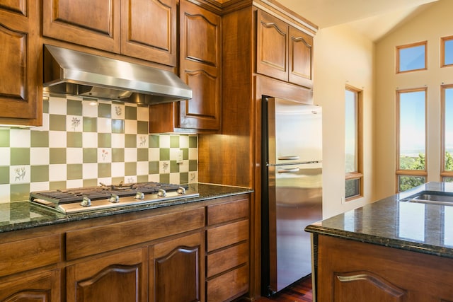 9 Canon Escondido, Sandia Park, NM 87047 - kitchen featuring range hood, appliances with stainless steel finishes, dark stone counters, tasteful backsplash, and vaulted ceiling