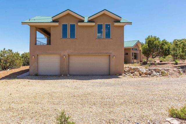 9 Canon Escondido, Sandia Park, NM 87047 - view of front of property with stucco siding, a garage, metal roof, and gravel driveway