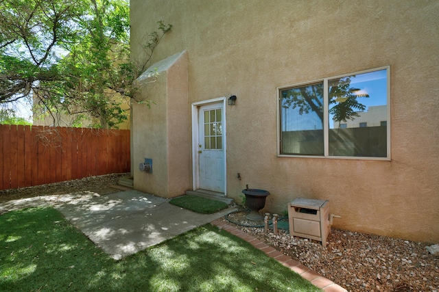 5209 Sugarbear Ct, Albuquerque, NM 87120 - view of exterior entry featuring fence, stucco siding, and a patio area
