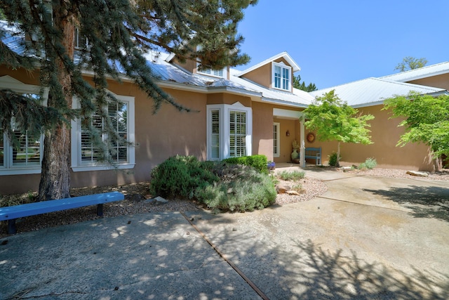 1513 Tinnin Rd NW, Los Ranchos, NM 87107 - view of front of property with stucco siding, a patio, and a metal roof