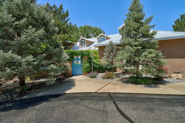 1513 Tinnin Rd NW, Los Ranchos, NM 87107 - obstructed view of property featuring metal roof, a gate, and stucco siding