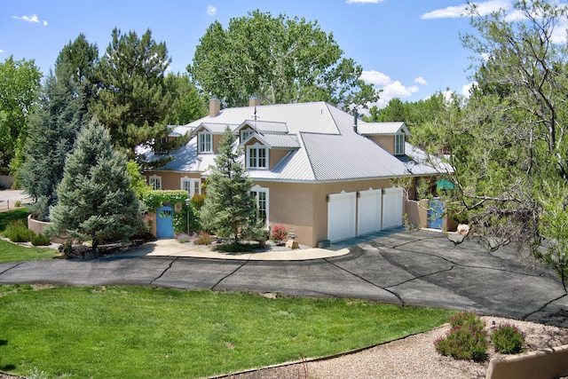 1513 Tinnin Rd NW, Los Ranchos, NM 87107 - new england style home featuring asphalt driveway, an attached garage, stucco siding, a chimney, and a metal roof