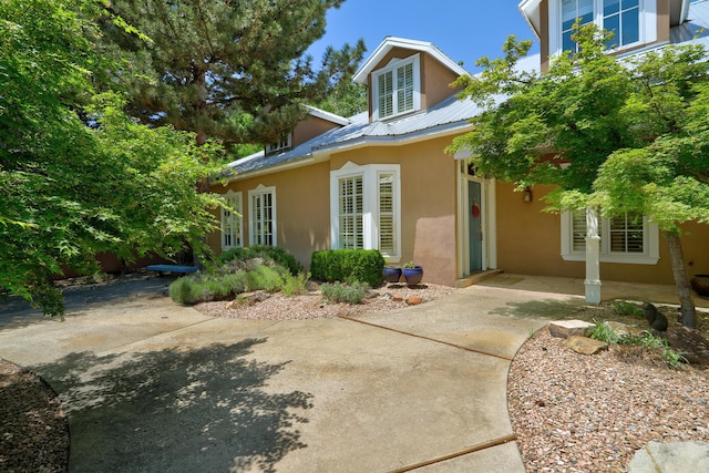 1513 Tinnin Rd NW, Los Ranchos, NM 87107 - view of exterior entry with stucco siding, a patio, a metal roof, and french doors