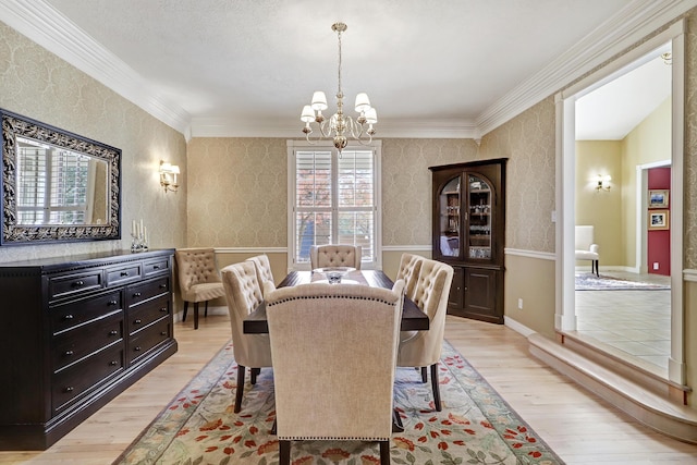 1513 Tinnin Rd NW, Los Ranchos, NM 87107 - dining room with light wood finished floors, a chandelier, and crown molding
