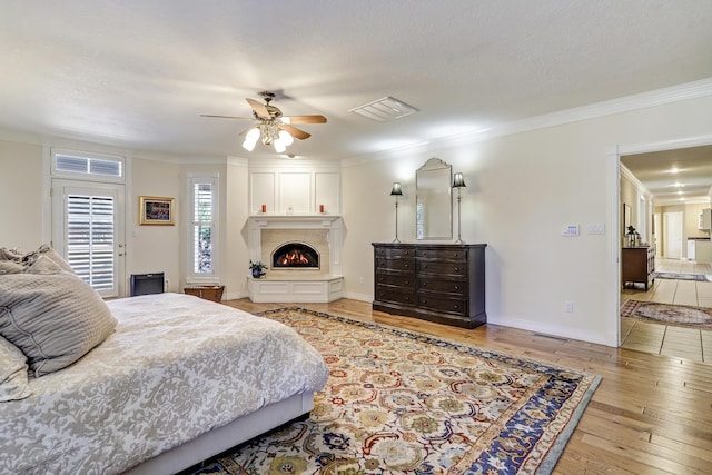1513 Tinnin Rd NW, Los Ranchos, NM 87107 - bedroom with wood-type flooring, ornamental molding, a fireplace, and a ceiling fan