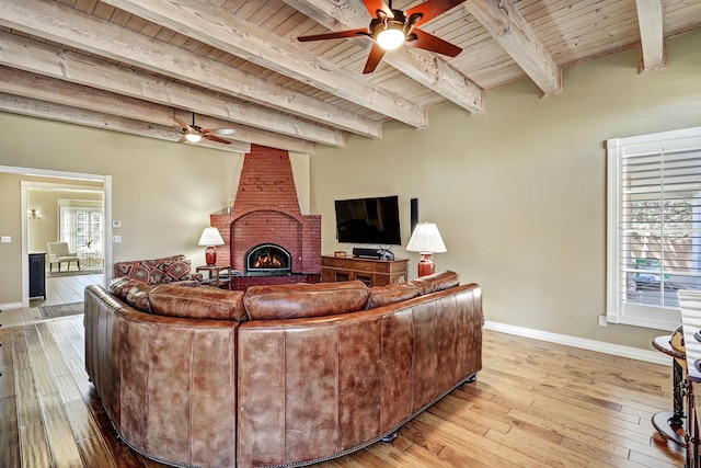 1513 Tinnin Rd NW, Los Ranchos, NM 87107 - living area with a ceiling fan, wooden ceiling with exposed beams, light wood-type flooring, baseboards, and a brick fireplace