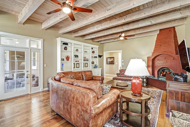 1513 Tinnin Rd NW, Los Ranchos, NM 87107 - living area featuring a ceiling fan, wood ceiling with exposed beams, baseboards, light wood-style floors, and a brick fireplace
