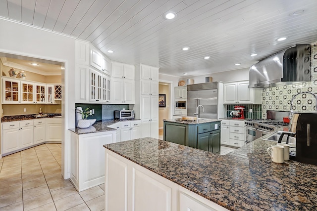 1513 Tinnin Rd NW, Los Ranchos, NM 87107 - kitchen featuring island exhaust hood, built in appliances, light tile patterned floors, recessed lighting, and white cabinets