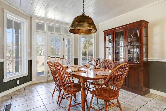 1513 Tinnin Rd NW, Los Ranchos, NM 87107 - dining area with plenty of natural light, light tile patterned floors, crown molding, wainscoting, and baseboards