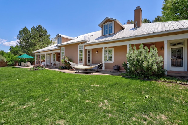 1513 Tinnin Rd NW, Los Ranchos, NM 87107 - back of house featuring a patio area, stucco siding, a lawn, and a chimney