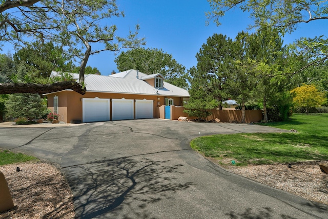 1513 Tinnin Rd NW, Los Ranchos, NM 87107 - view of side of home featuring a garage, driveway, stucco siding, and metal roof