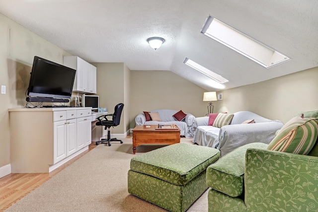 1513 Tinnin Rd NW, Los Ranchos, NM 87107 - living area with a skylight, light wood-type flooring, vaulted ceiling, baseboards, and a textured ceiling