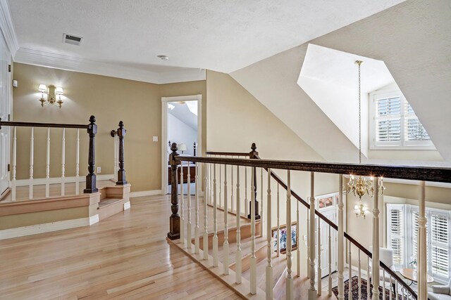 1513 Tinnin Rd NW, Los Ranchos, NM 87107 - hall featuring wood finished floors, a chandelier, an upstairs landing, and a textured ceiling