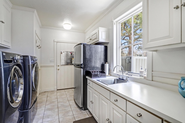 1513 Tinnin Rd NW, Los Ranchos, NM 87107 - kitchen featuring a sink, freestanding refrigerator, separate washer and dryer, white cabinetry, and ornamental molding