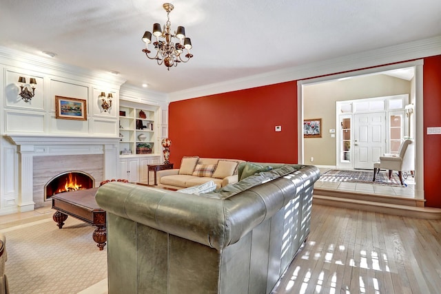 1513 Tinnin Rd NW, Los Ranchos, NM 87107 - living area with crown molding, a chandelier, built in shelves, light wood-style floors, and a tile fireplace