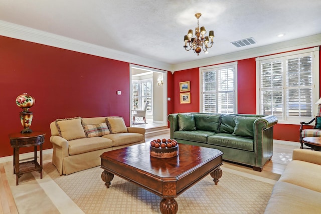 1513 Tinnin Rd NW, Los Ranchos, NM 87107 - living room featuring a chandelier, light wood-style floors, ornamental molding, and a textured ceiling
