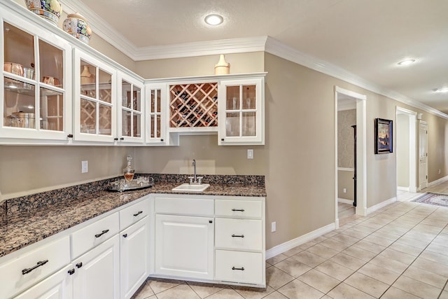 1513 Tinnin Rd NW, Los Ranchos, NM 87107 - kitchen with ornamental molding, light tile patterned floors, glass insert cabinets, white cabinetry, and dark stone counters