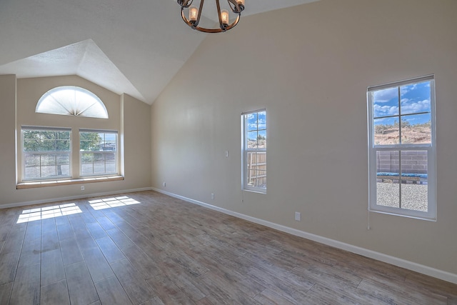 2308 Animas Ct NE, Rio Rancho, NM 87144 - spare room with a chandelier, wood finished floors, lofted ceiling, and baseboards