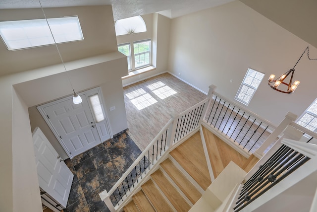 2308 Animas Ct NE, Rio Rancho, NM 87144 - foyer featuring a towering ceiling, healthy amount of natural light, a chandelier, baseboards, and stone finish flooring