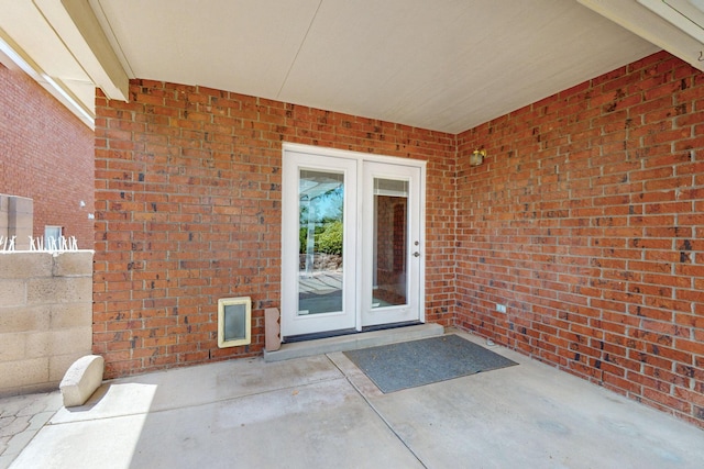 8720 Oakcrest Pl NW, Albuquerque, NM 87114 - property entrance with french doors, brick siding, and a patio area