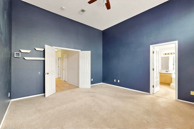 8720 Oakcrest Pl NW, Albuquerque, NM 87114 - unfurnished bedroom with carpet, baseboards, a towering ceiling, ensuite bathroom, and ceiling fan