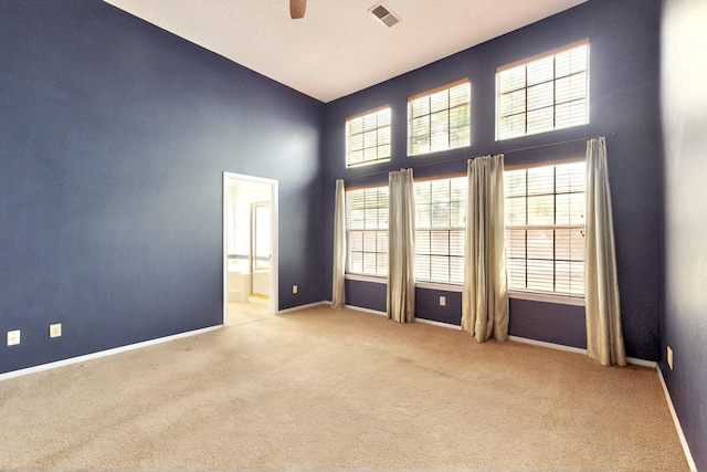 8720 Oakcrest Pl NW, Albuquerque, NM 87114 - carpeted spare room featuring a towering ceiling, baseboards, and a ceiling fan
