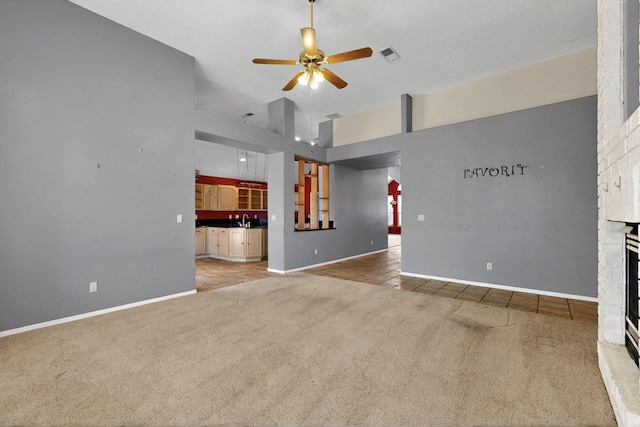 8720 Oakcrest Pl NW, Albuquerque, NM 87114 - unfurnished living room with light carpet, a ceiling fan, baseboards, a fireplace, and a high ceiling