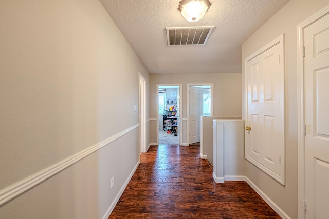 10500 Trieste Ct NW, Albuquerque, NM 87114 - hallway with dark wood-style flooring, a textured ceiling, and baseboards