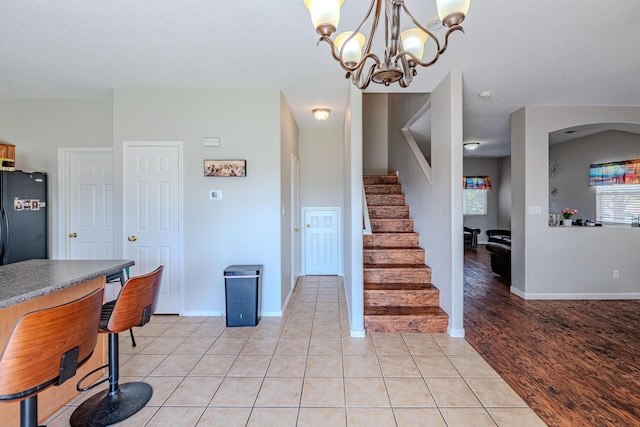 10500 Trieste Ct NW, Albuquerque, NM 87114 - dining room with stairs, baseboards, a chandelier, and light tile patterned floors
