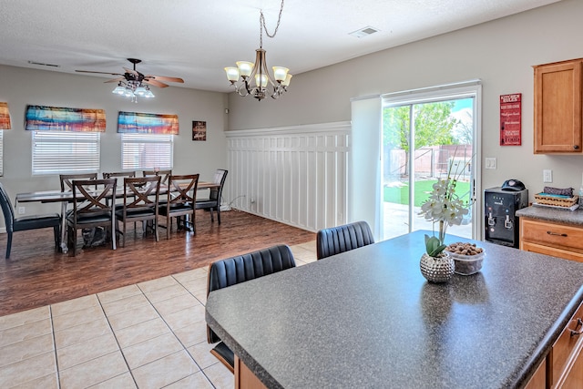 10500 Trieste Ct NW, Albuquerque, NM 87114 - dining room featuring ceiling fan, light tile patterned floors, and a chandelier