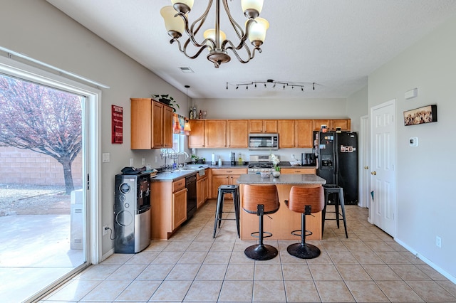 10500 Trieste Ct NW, Albuquerque, NM 87114 - kitchen featuring black appliances, a sink, a chandelier, light tile patterned floors, and a breakfast bar