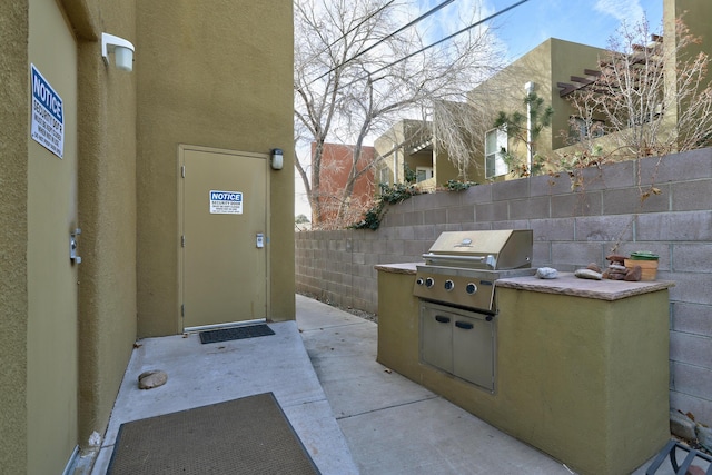 351 Washington St SE Unit 102, Albuquerque, NM 87108 - view of patio with a grill, fence, and an outdoor kitchen