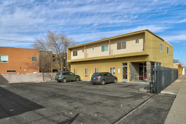 351 Washington St SE Unit 102, Albuquerque, NM 87108 - view of front of house with fence, uncovered parking, and stucco siding