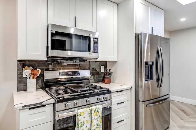 6507 Loftus Ave NE, Albuquerque, NM 87109 - kitchen featuring appliances with stainless steel finishes, decorative backsplash, light stone counters, white cabinetry, and recessed lighting