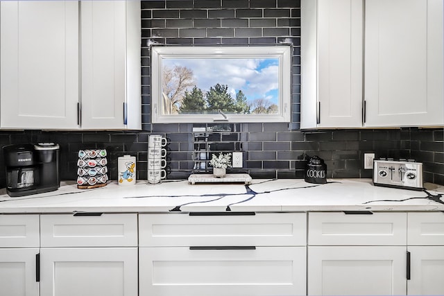 6507 Loftus Ave NE, Albuquerque, NM 87109 - kitchen featuring white cabinetry, decorative backsplash, and light countertops