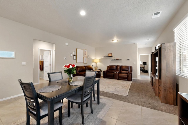 3179 Kunzita St SE, Rio Rancho, NM 87124 - dining room with light tile patterned floors, a textured ceiling, and light colored carpet