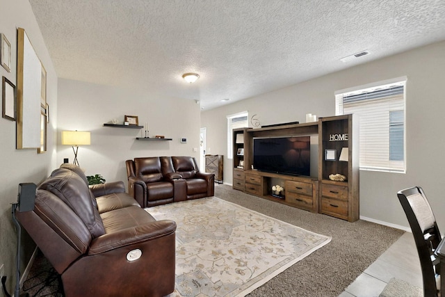 3179 Kunzita St SE, Rio Rancho, NM 87124 - living area featuring a textured ceiling, carpet, baseboards, and tile patterned flooring