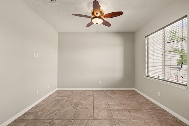 4909 Calle Espana NW, Albuquerque, NM 87120 - tiled empty room with a textured ceiling, a ceiling fan, and baseboards
