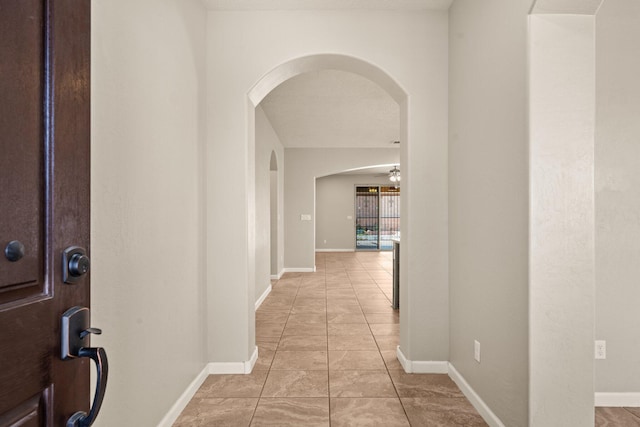 4909 Calle Espana NW, Albuquerque, NM 87120 - corridor featuring arched walkways, baseboards, and light tile patterned flooring