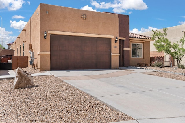 4909 Calle Espana NW, Albuquerque, NM 87120 - southwest-style home featuring stucco siding, driveway, an attached garage, fence, and a tile roof