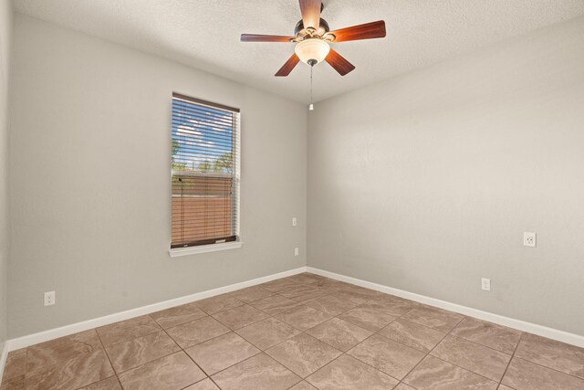 4909 Calle Espana NW, Albuquerque, NM 87120 - spare room with a textured ceiling, a ceiling fan, light tile patterned floors, and baseboards