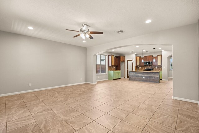 4909 Calle Espana NW, Albuquerque, NM 87120 - unfurnished living room featuring arched walkways, recessed lighting, ceiling fan, light tile patterned floors, and a textured ceiling